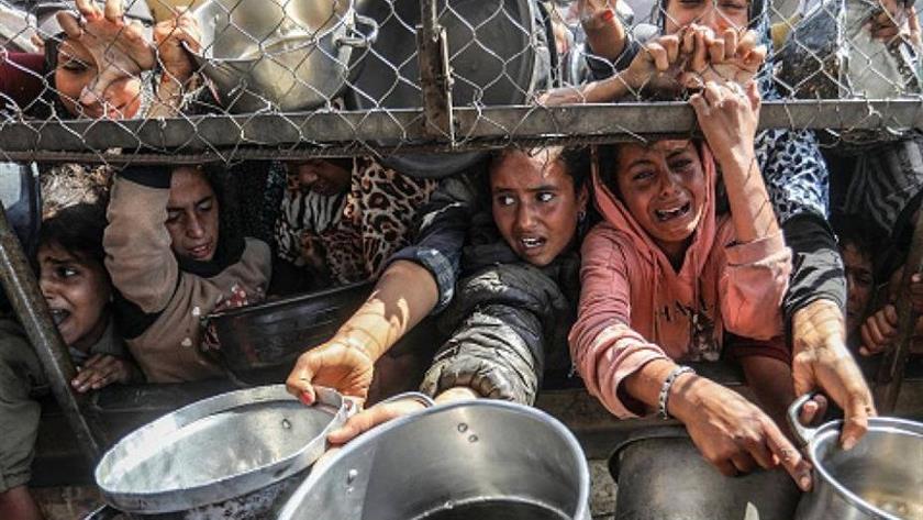 Iranpress: تعاون حراس أمن أميركيين مع الصهاينة في قتل الفلسطينيين الجائعين