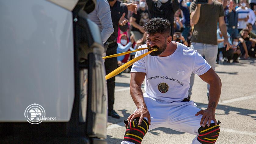 Iranpress: Iranian athlete breaks record of moving trucks