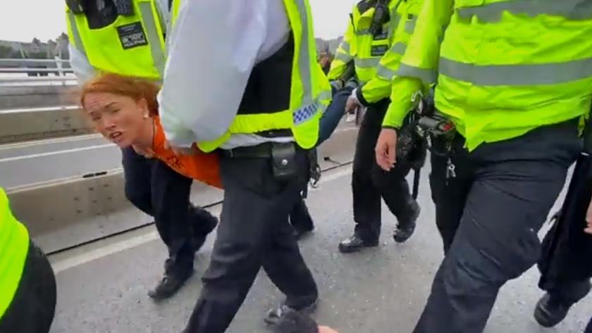 Iranpress: 6 UK police officers carry woman after arrest during protest